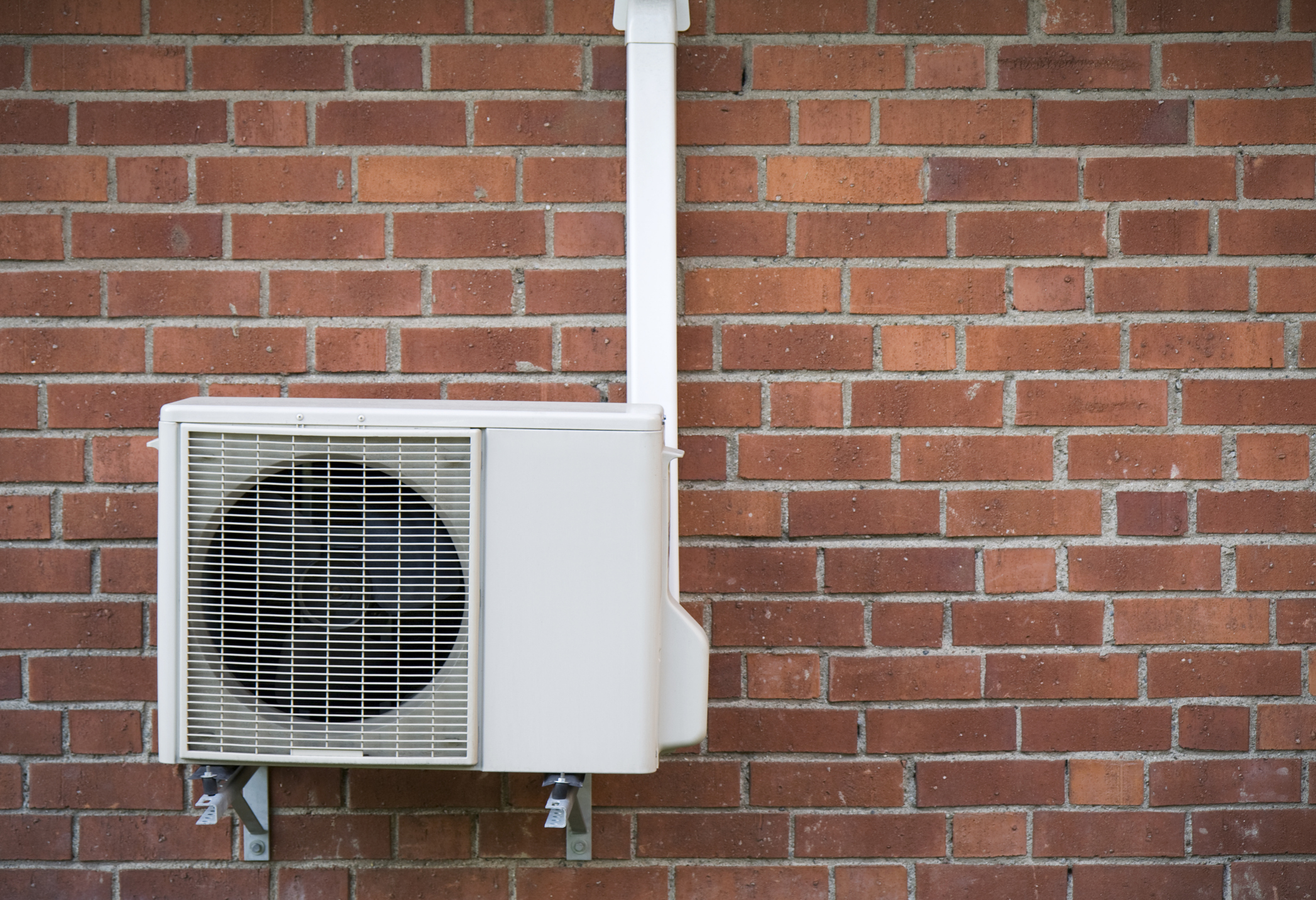 Heat Pump Against Brick Wall