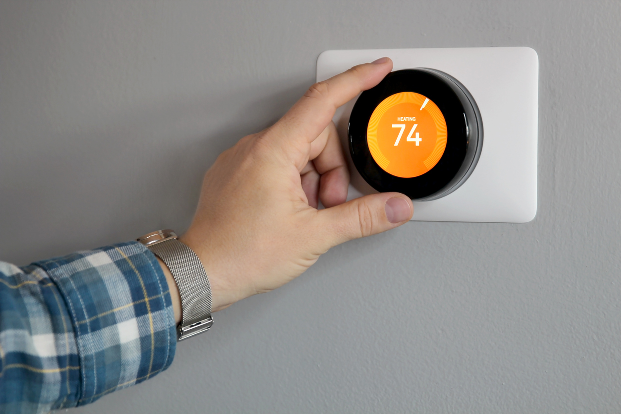 Man Adjusting Thermostat Set to Heat