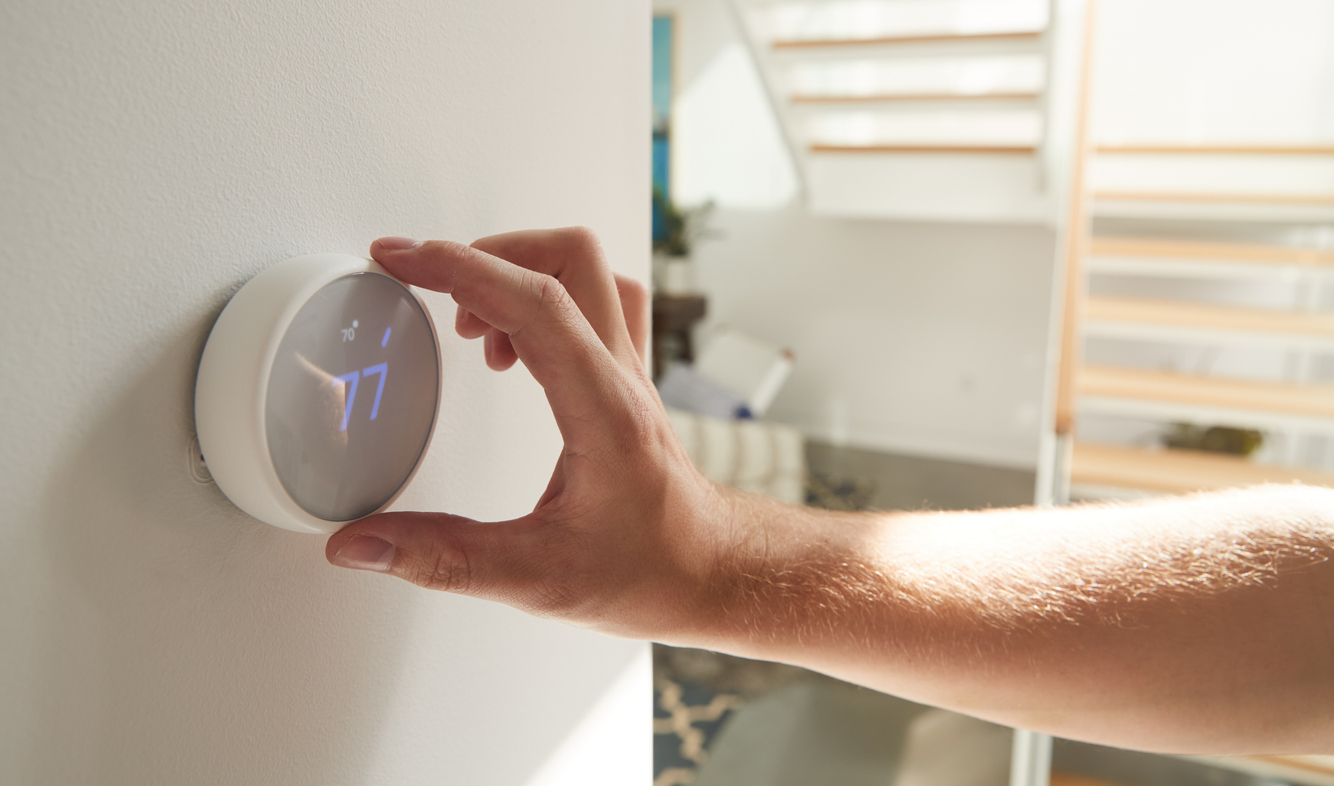 Man Adjusting Thermostat Set to Heat